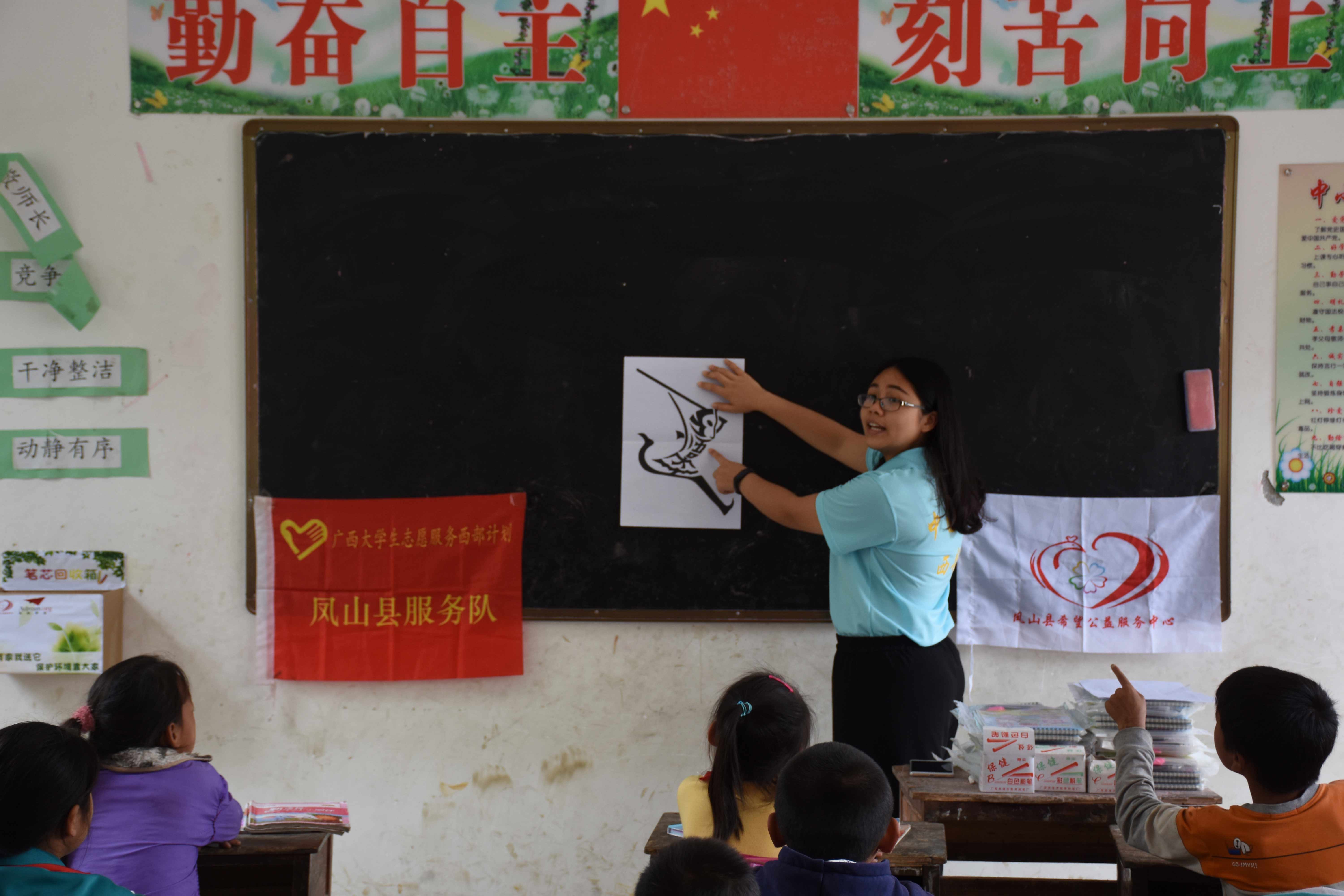 图为志愿者以图画为学生展示汉字的魅力.jpg