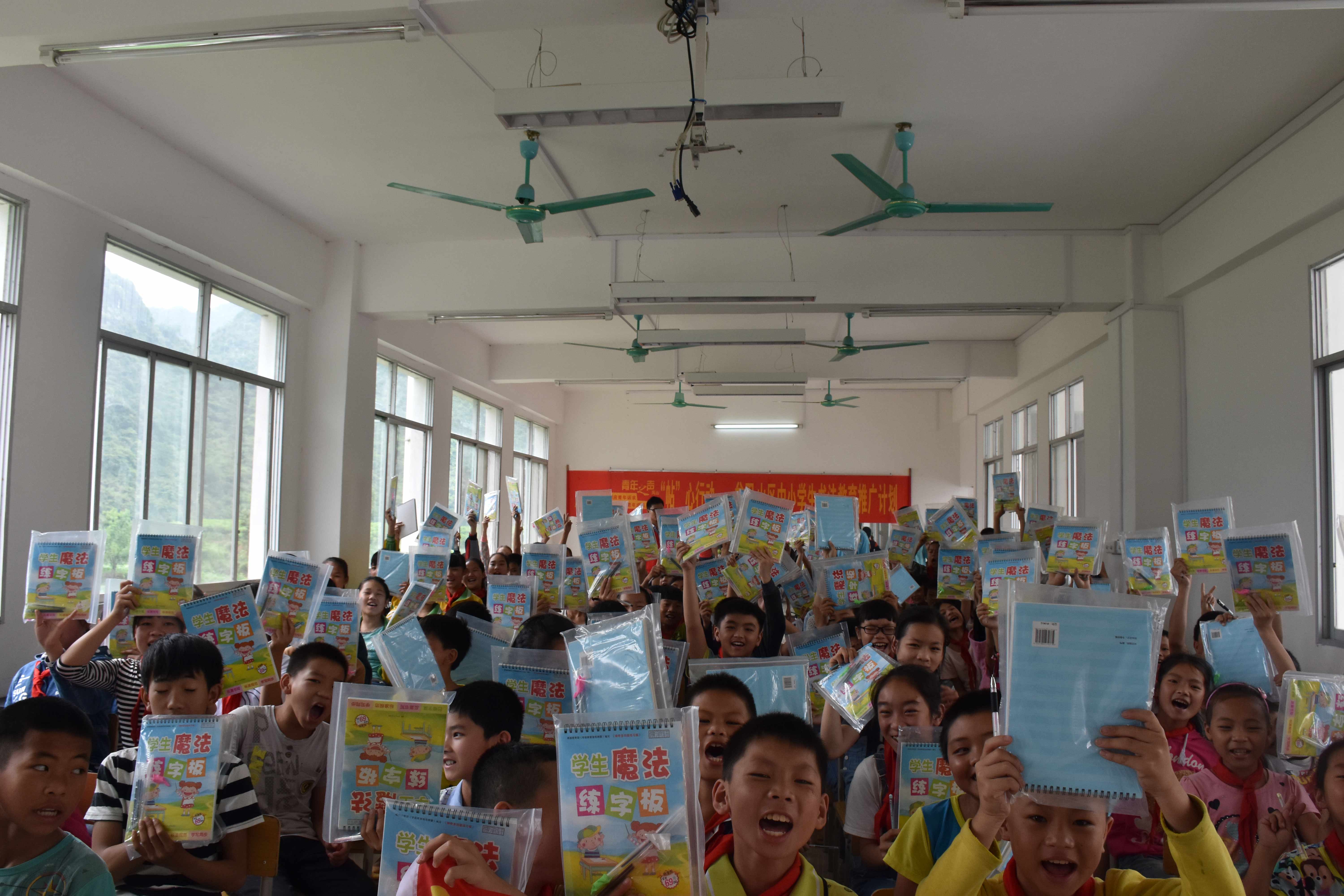 图为：志愿者给学生送来新字帖.jpg